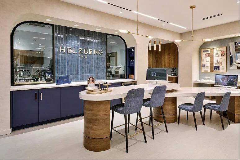A Helzberg shopping bag being handed to a customer over the checkout counter.