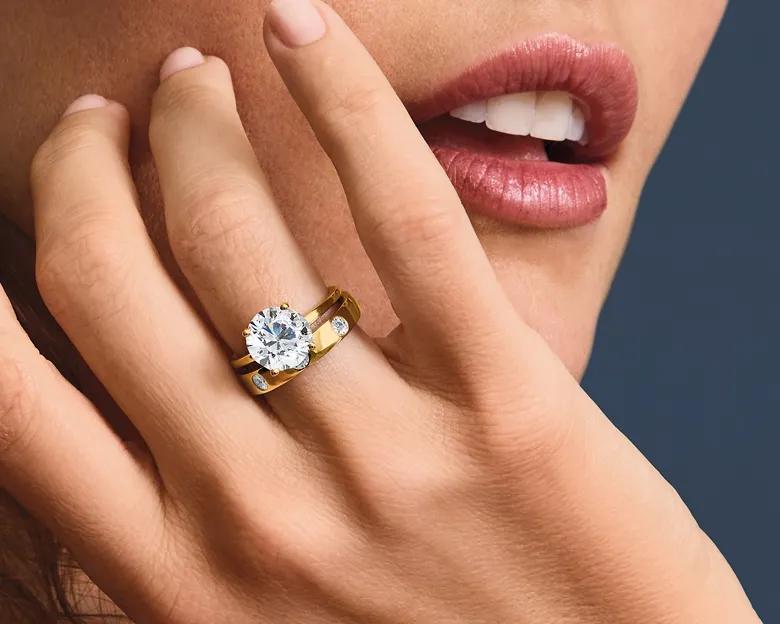 A model wearing an engagement band and wedding ring.
